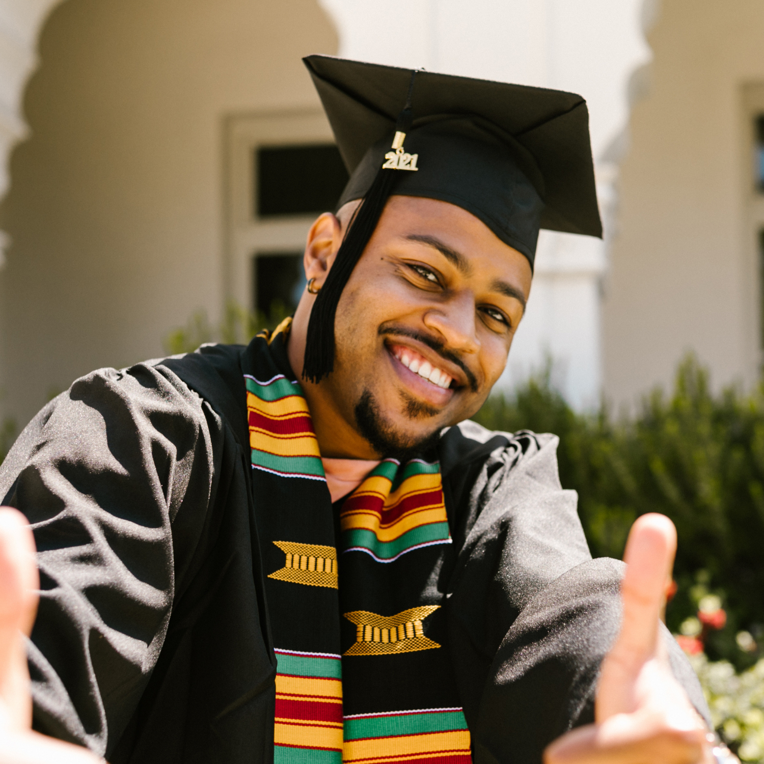 Man wearing graduation cap and gown smiling and giving thumbs up - The Whitening Store website home page.