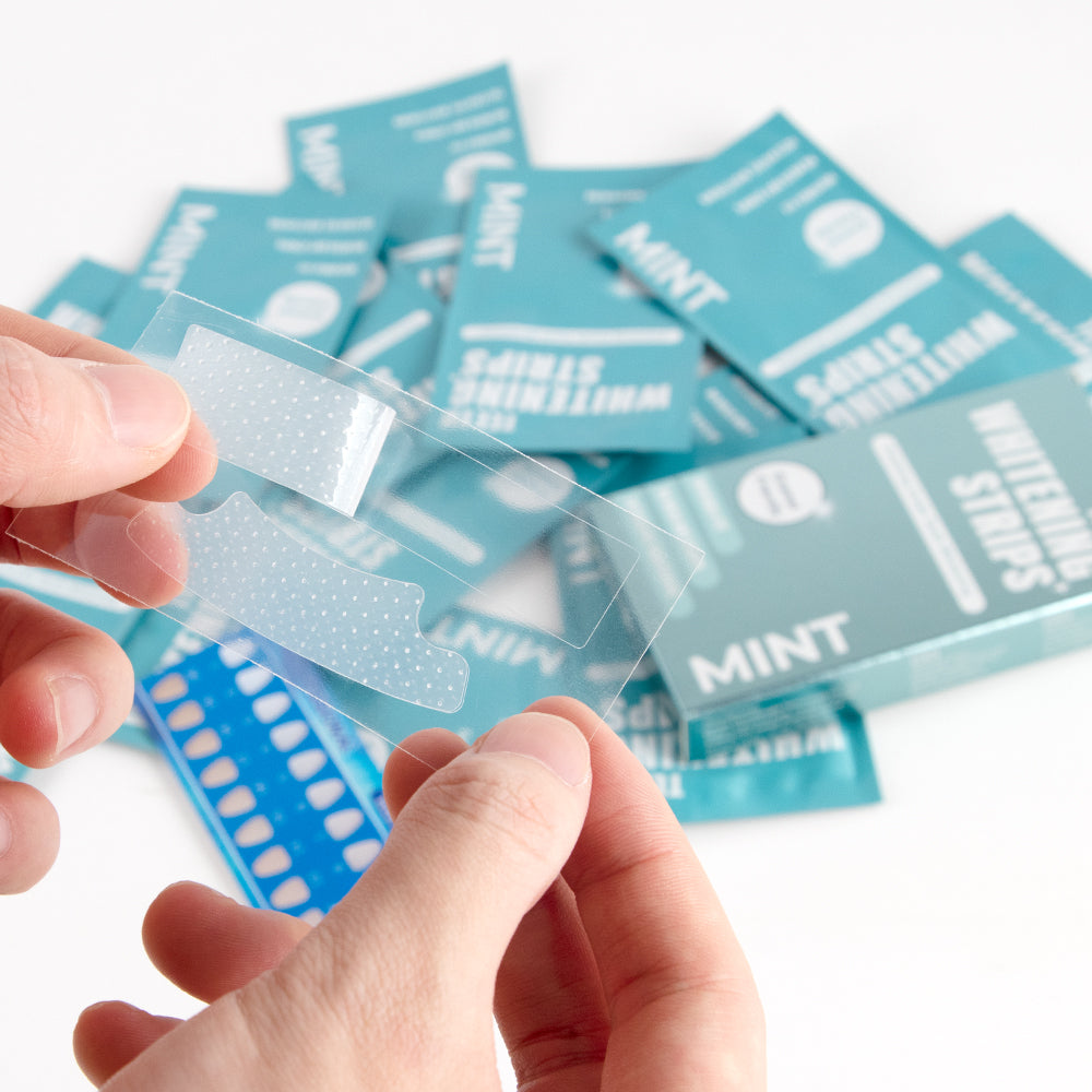 The Whitening Store's teeth whitening strips in hands.