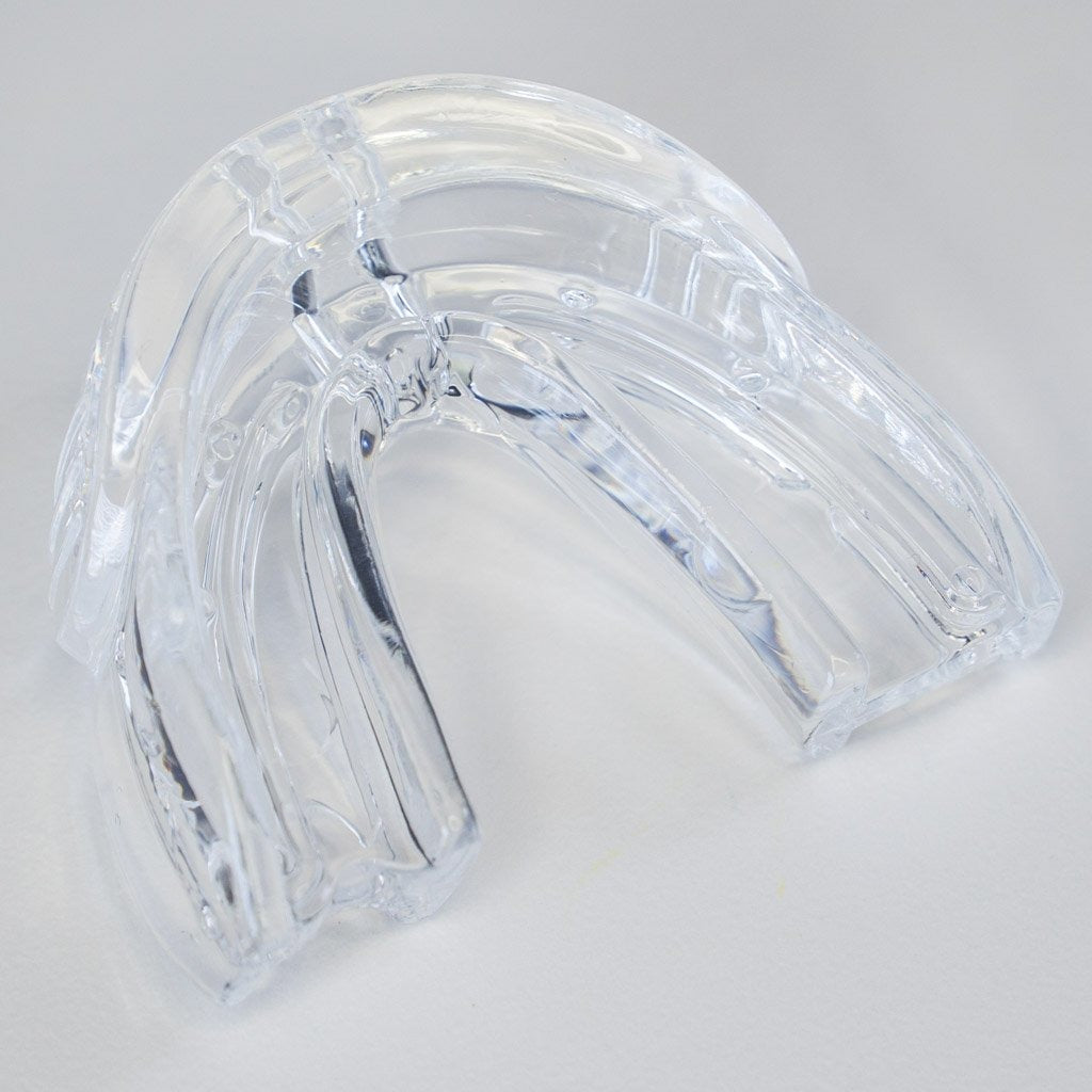 White in Minutes teeth whitening mouth tray view from back with impressions and trays shape visible on grey background