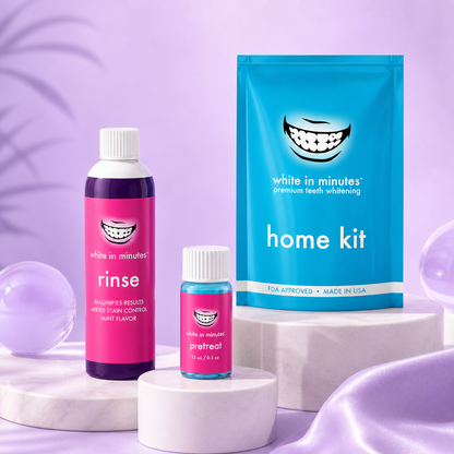 White in Minutes Everyday Radiance Set displayed on soft lavender background with pretreat bottle, home whitening kit, and purple rinse arranged on elevated pedestals in a clean, modern product scene.
