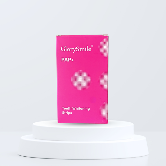 Pink box of GlorySmile PAP+ teeth whitening strips on a white pedestal with a light gray background