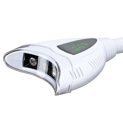 White pro20 teeth whitening lamp head shown at an angle on a white background, featuring a clear curved front shield, internal LED light components, side ventilation slots, ribbed neck, and a dark gray top control panel with green indicator lights.