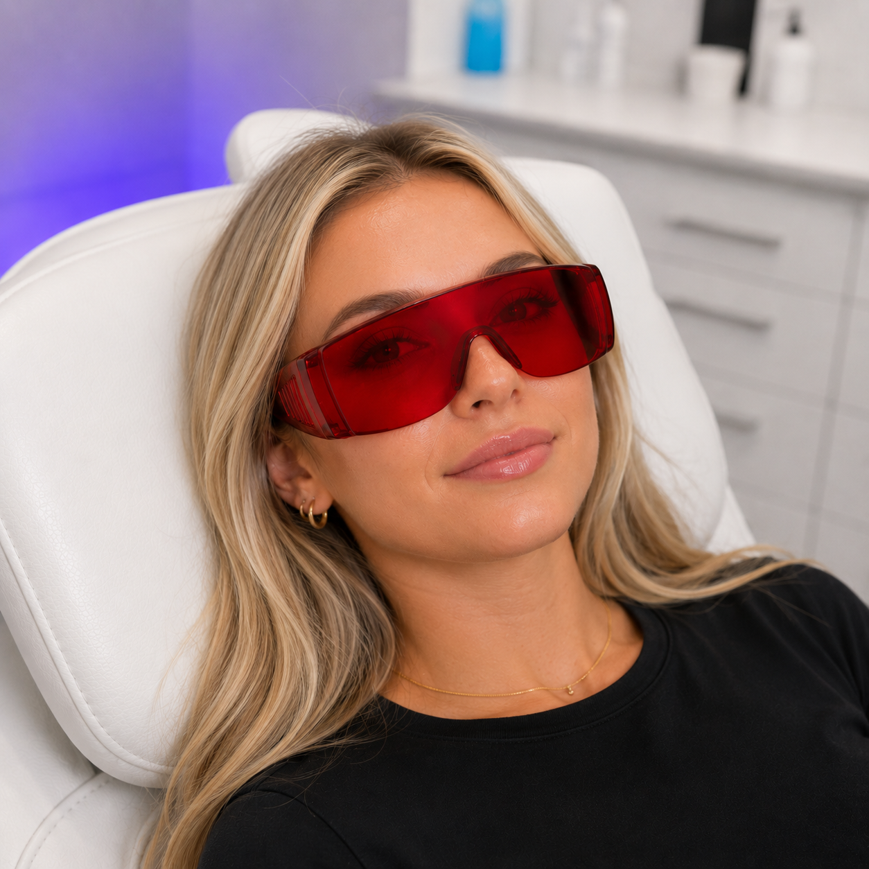 Woman wearing red protective glasses for teeth whitening eye cover in a clinical setting
