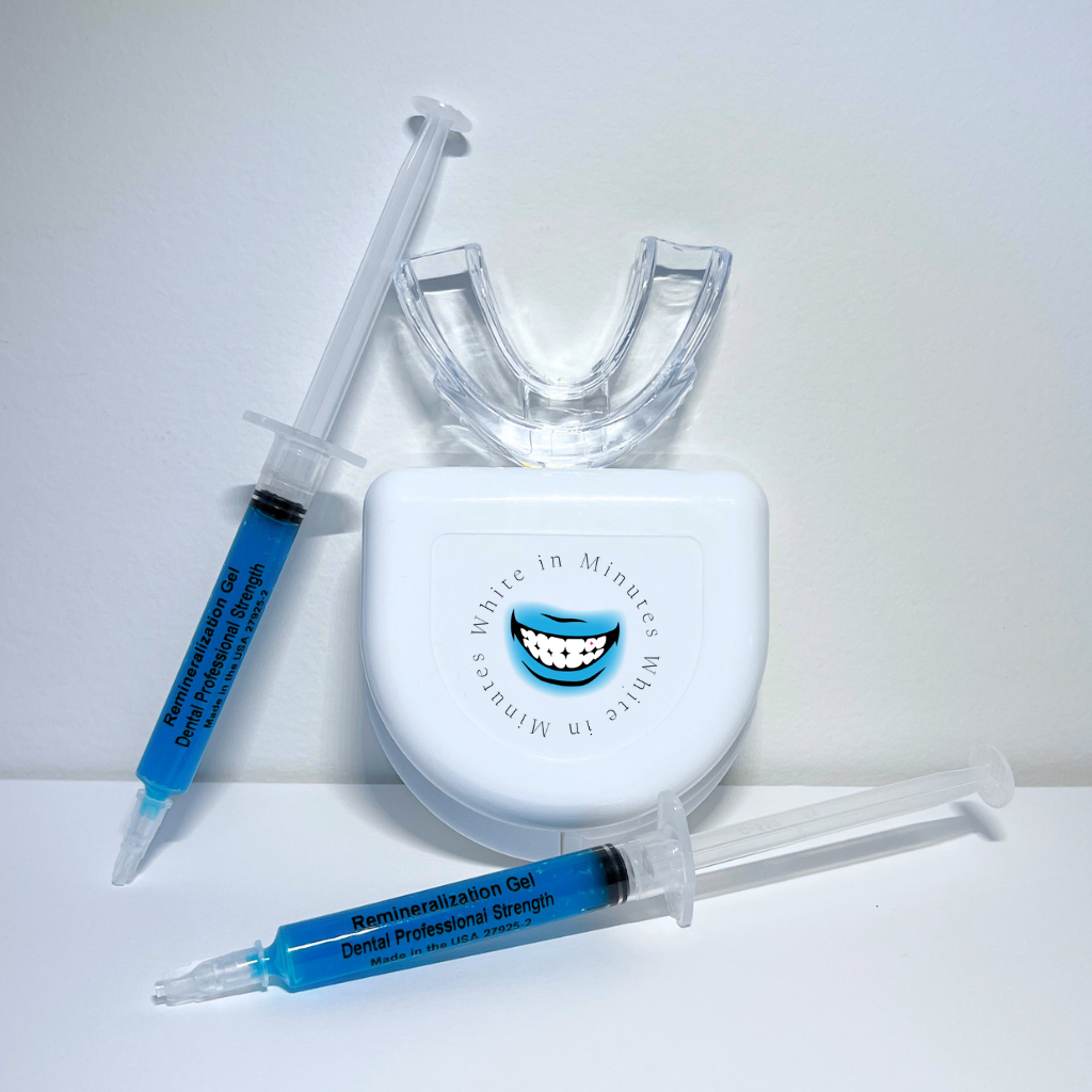 Image of tooth remineralizing kit on white background including two 3ml syringes with blue remineralizing gel, a clear mouth tray, and a tray case.