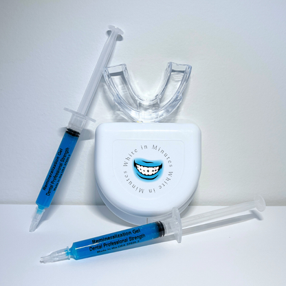 Image of tooth remineralizing kit on white background including two 3ml syringes with blue remineralizing gel, a clear mouth tray, and a tray case.
