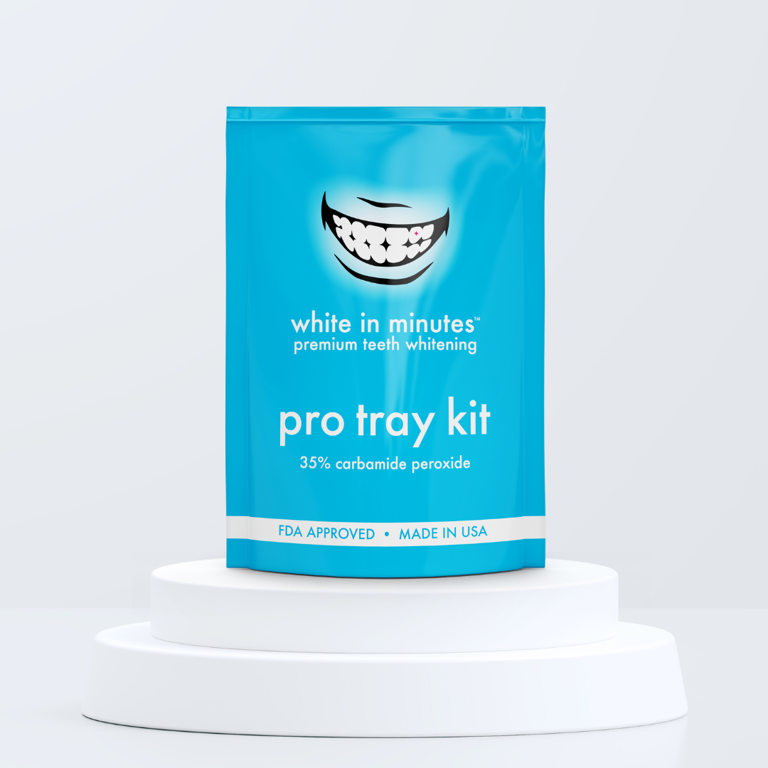 Blue package of 'white in minutes' teeth whitening pro tray kit on a white pedestal with a light gray background