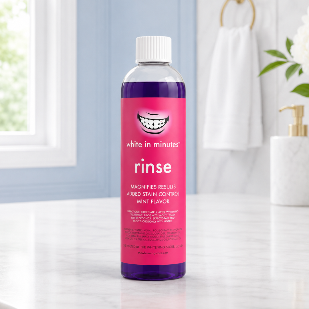 White in Minutes® Whitening Rinse bottle filled with purple mouthwash standing on a white marble bathroom countertop in a bright modern bathroom with a window, white flowers, and gold accents.