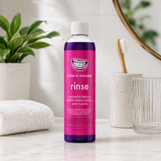 White in Minutes purple whitening mouthwash bottle on a marble bathroom counter with towel, plant, and toothbrush, modern clean setting.