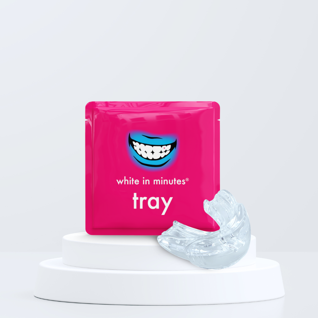 Pink packaging of 'white in minutes tray' with a clear dental tray on a white background