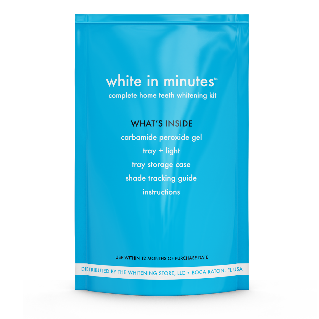 A bright blue White in Minutes Complete Home Teeth Whitening Kit pouch shown upright on a white background. The back of the package lists the kit contents: carbamide peroxide whitening gel, whitening tray with LED light, tray storage case, shade tracking guide, and instructions, along with a 12-month use-by notice and The Whitening Store distributor information.